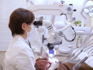 デンタルサロンナチュール銀座で、歯科医師がマイクロスコープ（歯科用顕微鏡）を使用して行う精密な歯科治療。